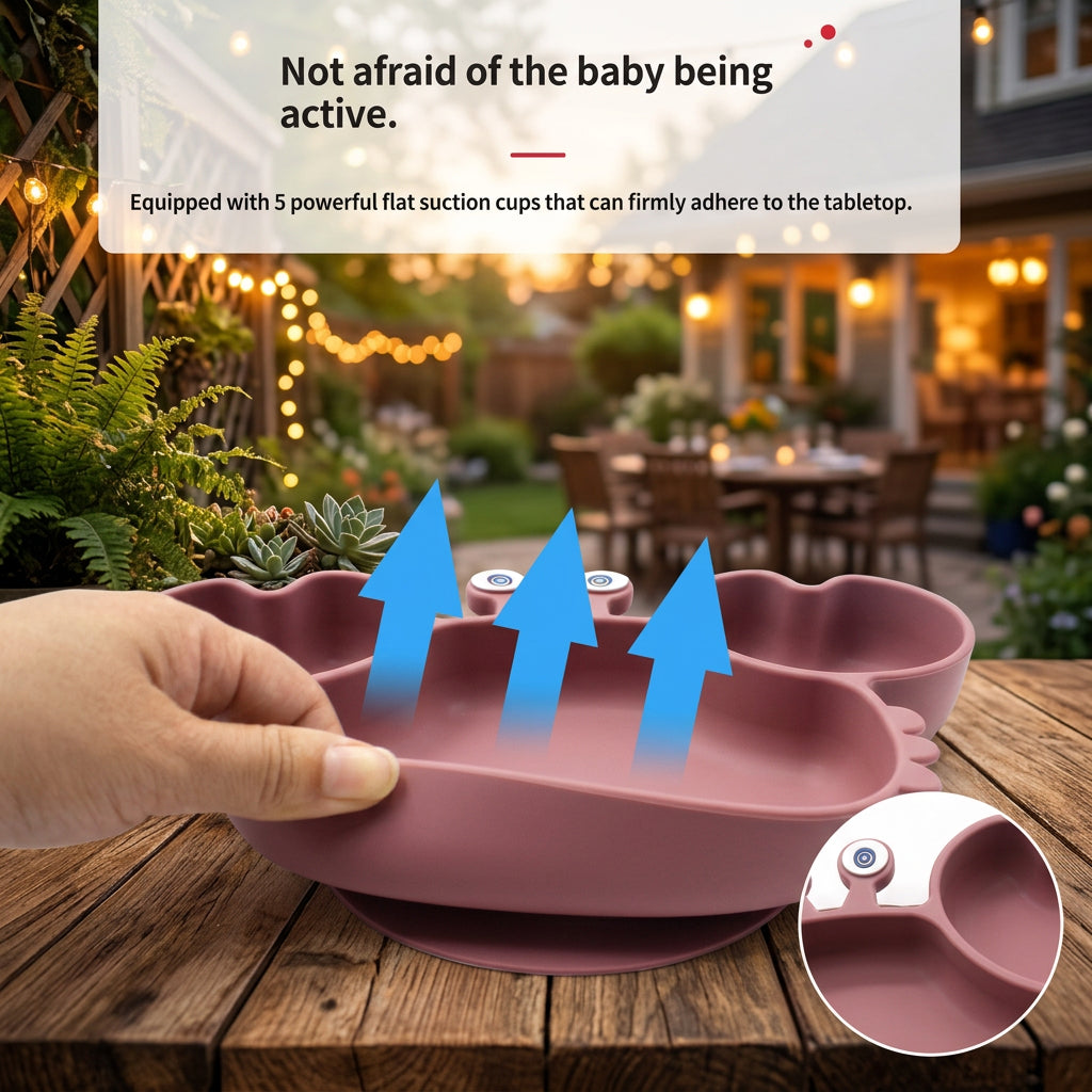 A silicone baby feeding tray in dusty pink is being held by a hand on a wooden table, with a blurred outdoor patio background. Blue arrows overlay the tray indicating suction cups, and text at the top describes suction cup functionality.